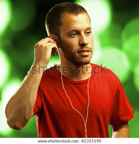 man listening to music with earphones against a lights background