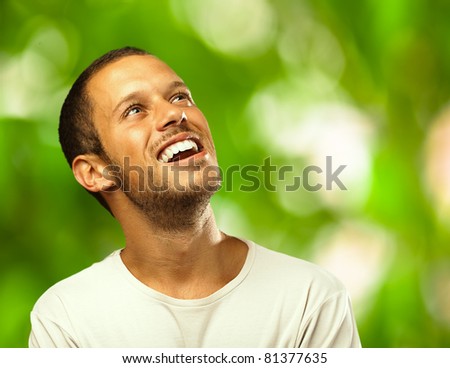 man laughing looking up against a plants background