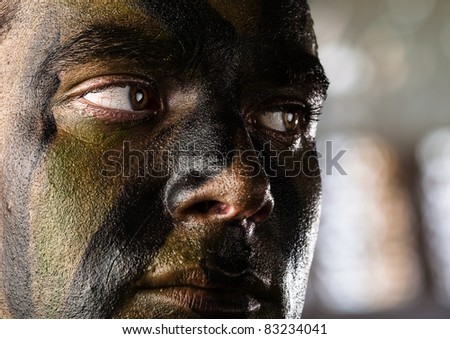young soldier face with jungle camouflage, outdoor
