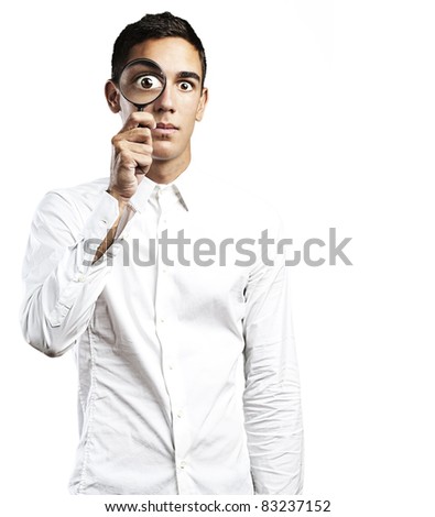 portrait of handsome young man looking through a magnifying glass on white background