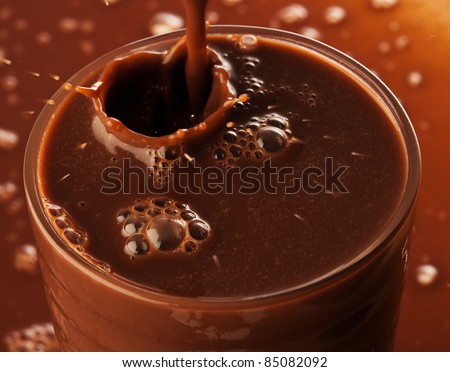 extreme closeup of Chocolate splashing on glass