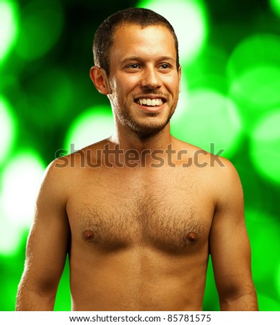 man shirtless smiling on a green lights background