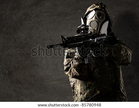 portrait of soldier with rifle and gas mask against a grunge background
