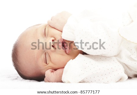 portrait of newborn baby sleeping in a bed over white background