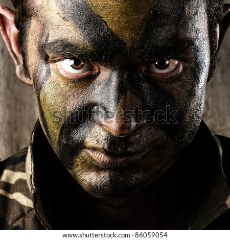 young soldier face looking straight ahead against a a grunge wall