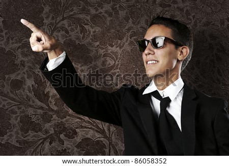portrait of young business man pointing up against a grunge background