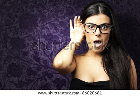 portrait of surprised young woman hearing a sound against a vintage wall