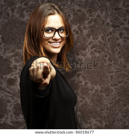 portrait of young woman pointing with finger against a vintage background