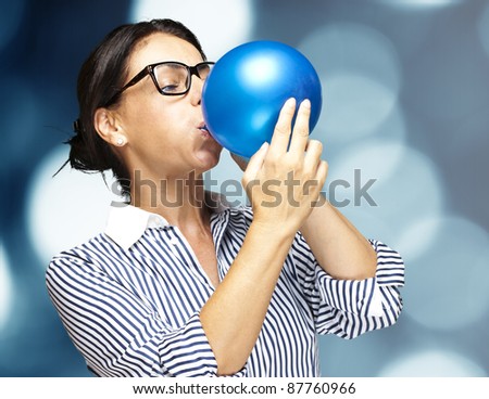 portrait of a middle aged woman blowing a balloon against a abstract background