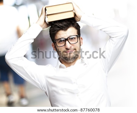 portrait of young student holding books at a crowded place