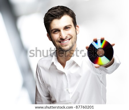 portrait of a handsome young man holding cd indoor