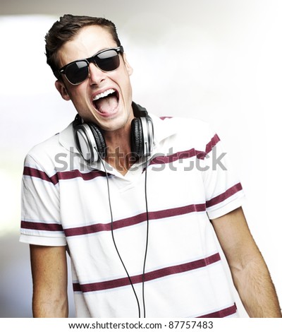 portrait of handsome young man singing and listening to music indoor