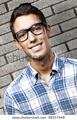 portrait of a handsome young man smiling against a grunge bricks wall