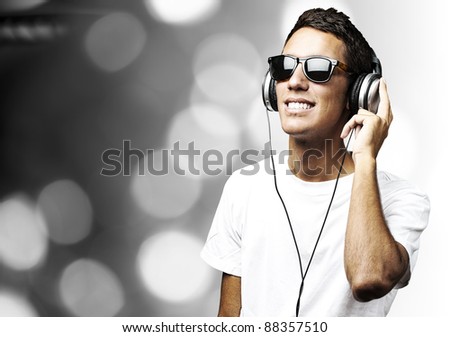 portrait of a handsome young man listening to music against a abstract background