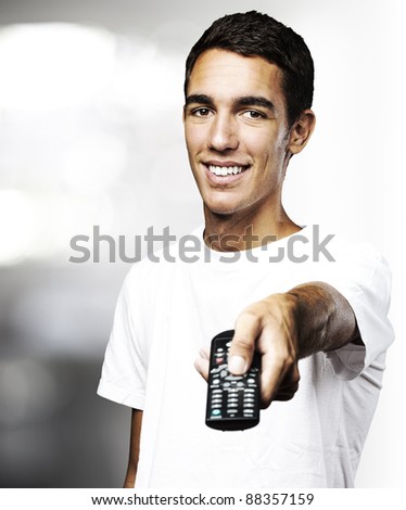 portrait of a handsome young man using tv control indoor