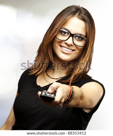 portrait of young woman with glasses changing channel with tv control indoor