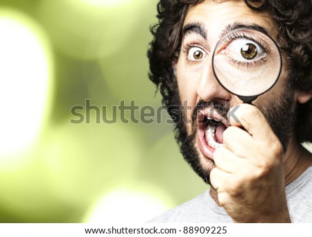 portrait of young scientific looking through a magnifying glass against a nature background