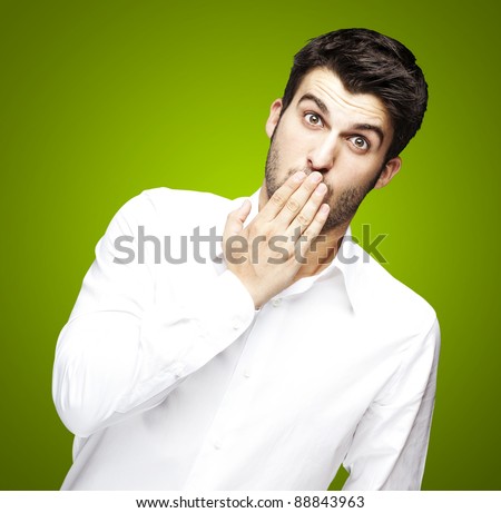 stock-photo-portrait-of-young-man-covering-his-mouth-with-hand-over-green-88843963.jpg