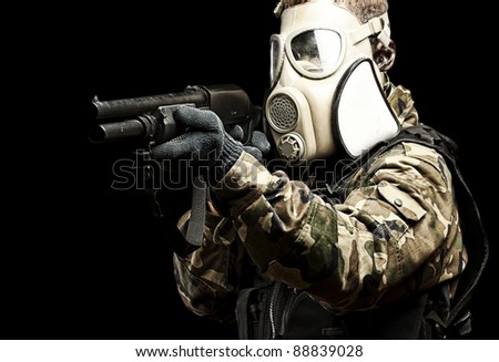 portrait of young soldier with gas mask aiming with shotgun