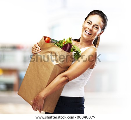 portrait of middle aged woman holding the purchase at a crowded place