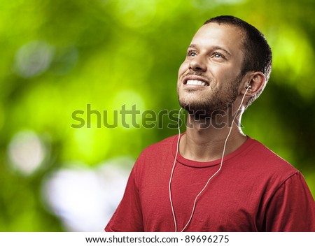 young man listen to music against a plants background