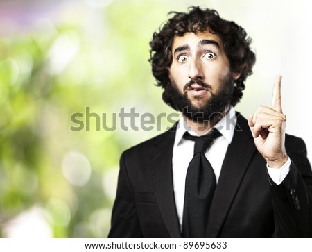 portrait of business man pointing up against a nature background