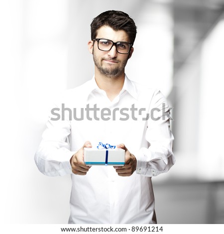 portrait of young man giving a gift indoor