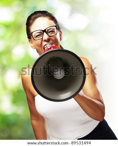 portrait of middle aged woman shouting with megaphone at outdoor