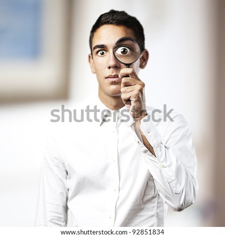 portrait of handsome young man with a magnifying glass in a house