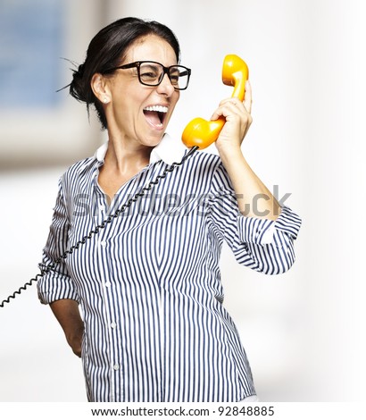portrait of a middle aged woman talking on vintage telephone indoor