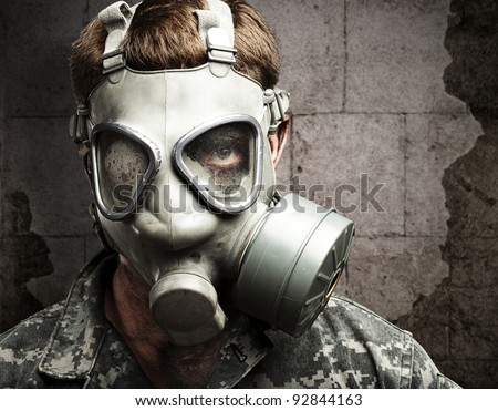portrait of young soldier wearing gas mask against a vintage wall