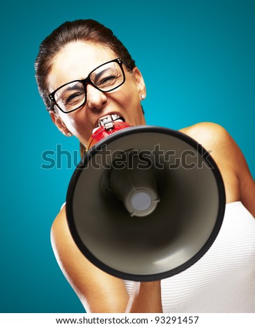 portrait of a middle aged woman shouting with a megaphone over a blue background