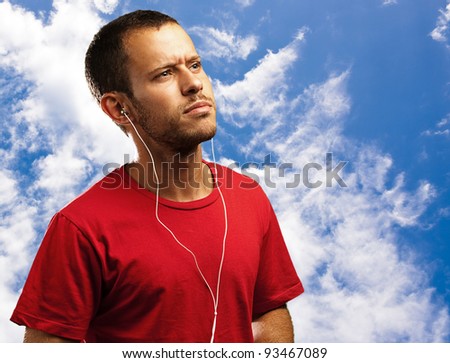 young man listen to music on a blue sk background