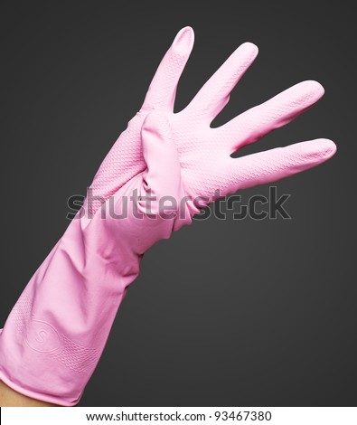 pink gloves of maid gesturing number four against a black background