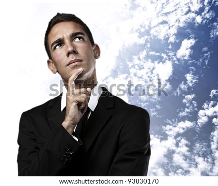 portrait of a business man thinking against a cloudy sky background