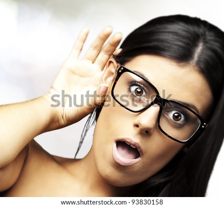 portrait of a pretty young woman surprised hearing a sound indoor