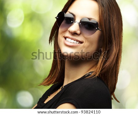 portrait of a pretty young woman smiling against a green background