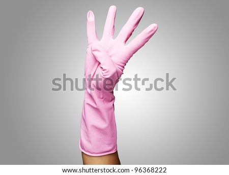 pink gloves of maid gesturing number four against a grey background