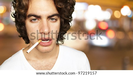portrait of a sad smoker at a crowded city background