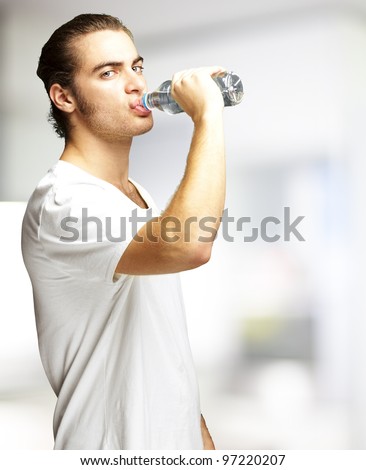 portrait of a young man drinking water indoor