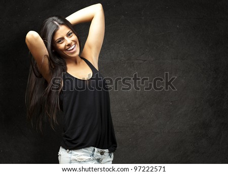 portrait of a pretty young woman posing against a grunge wall