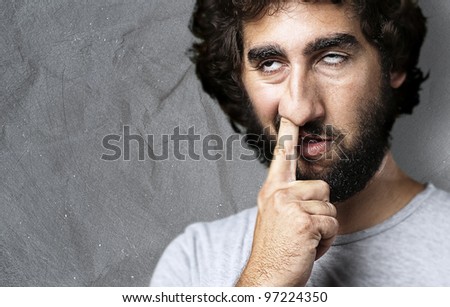stock-photo-portrait-of-a-young-man-with-his-finger-in-his-nose-against-a-grunge-background-97224350.jpg