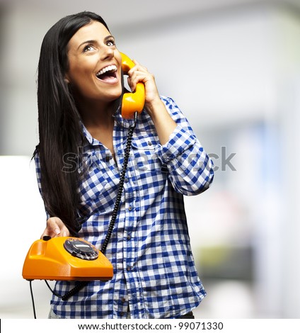 portrait of young woman talking on vintage telephone indoor