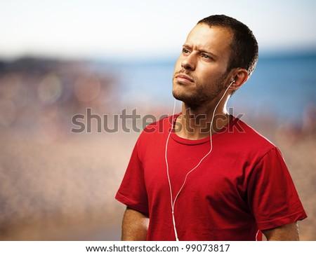 young man listen to music near the beach