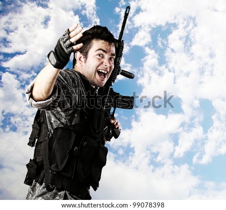 portrait of young soldier running against a cloudy sky background