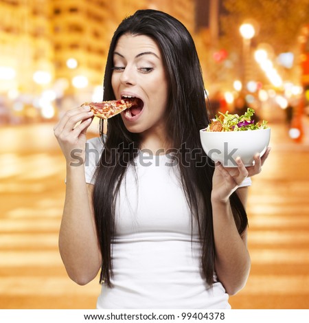 woman choosing a slice of pizza instead of a salad against a city night background