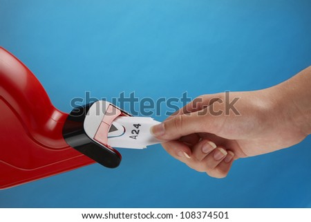 customer pulls a numbered ticket out of red take one machine, with space for copy