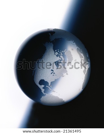Glass globe with etched continents on white to dark background