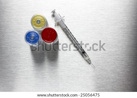 A hypodermic needle with injectable drugs on stainless steel background