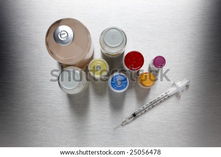 A hypodermic needle with injectable drugs on stainless steel background